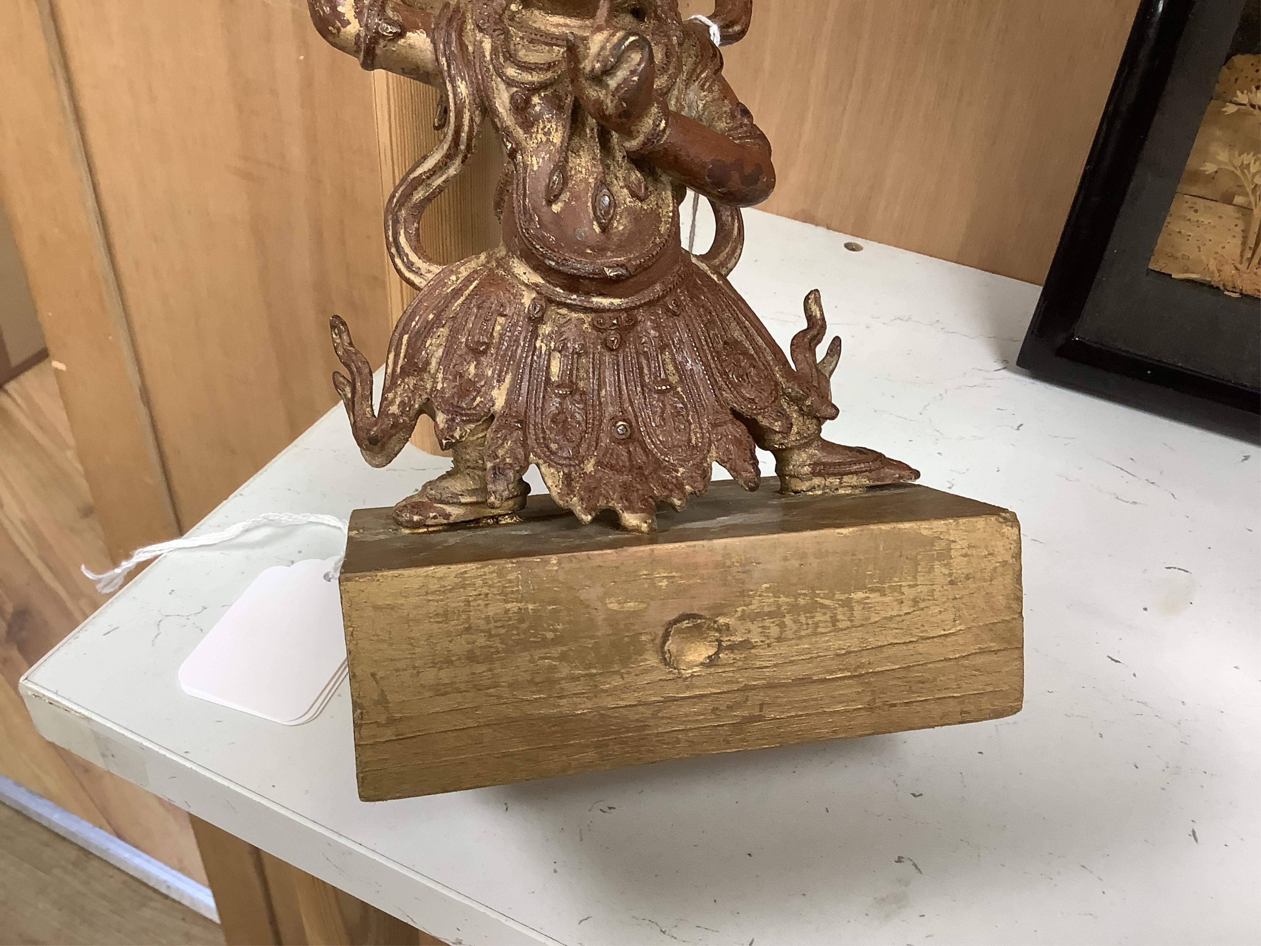 A Buddhist gilt bronze figure of Vaishravana, possibly Tibetan, 21 cm including wooden stand.